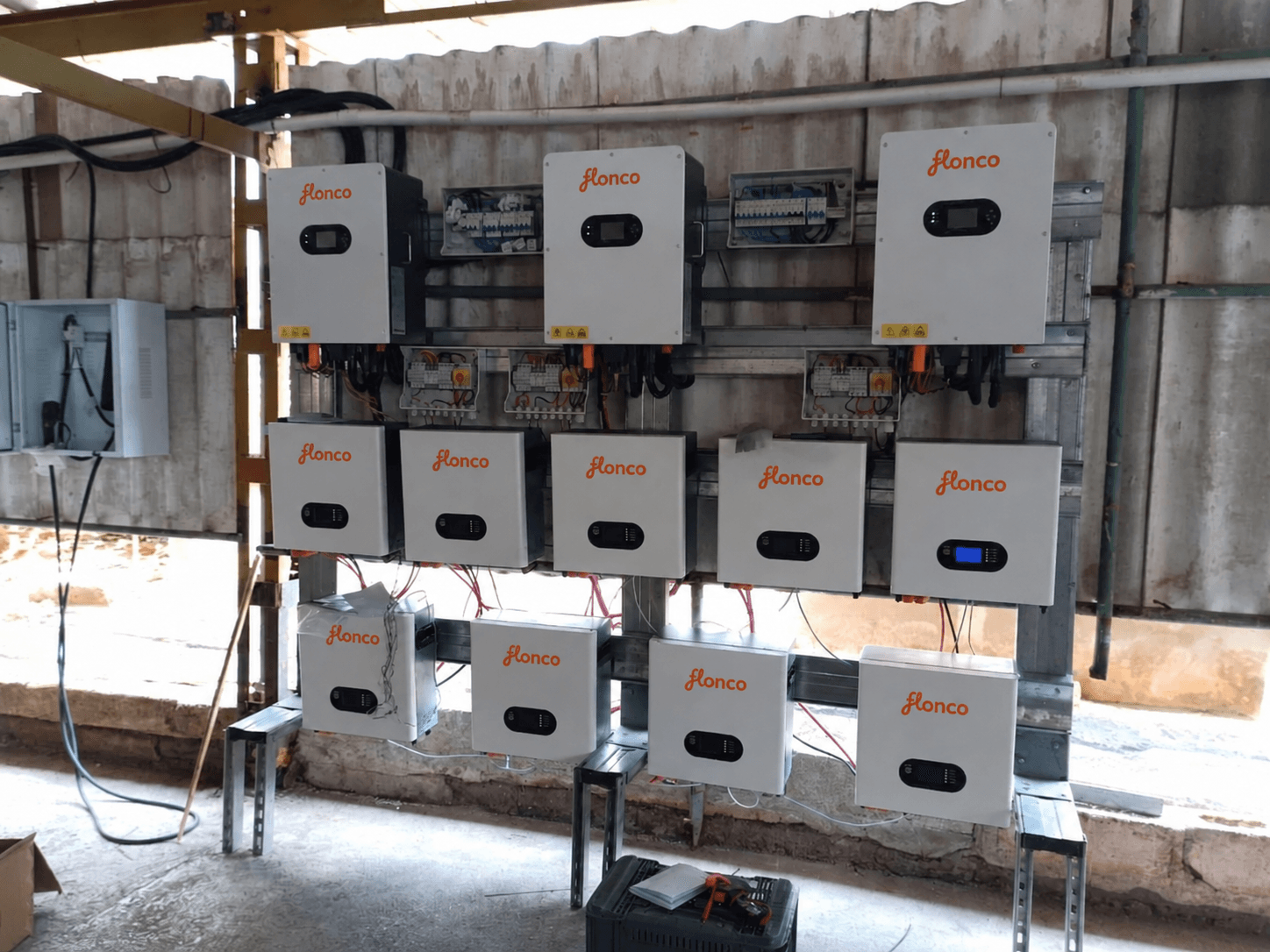 Three hybrid inverters and nine wall-mounted batteries at the Chile farm installation; FLONCO wordmarks digitally added