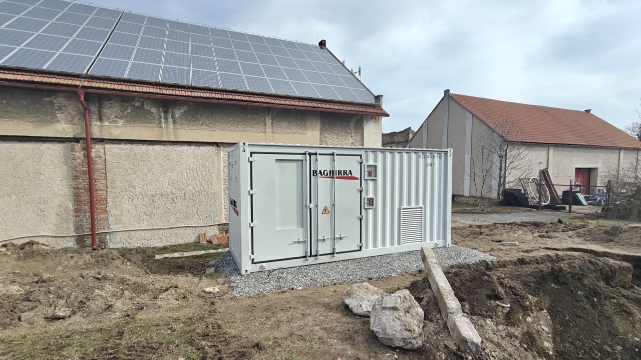 BESS container beside a building with rooftop solar panels in the Czech Republic